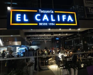 Bright LED illuminated business sign on commercial building exterior at night, permit required example